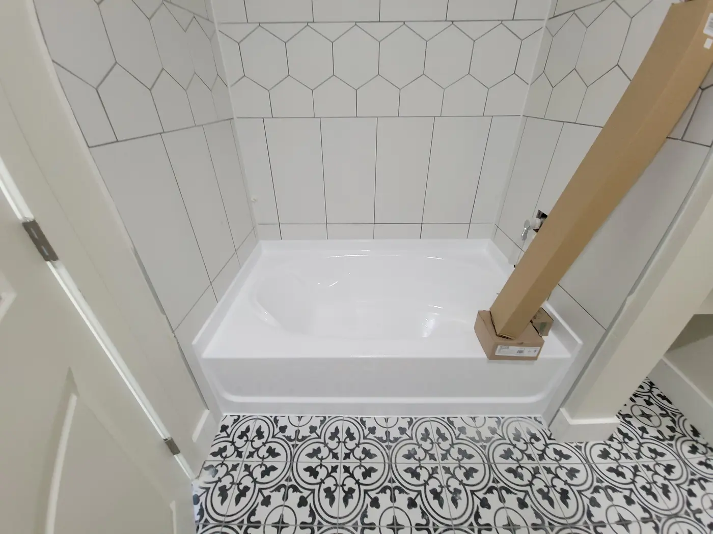 White tub surround tile installation in progress